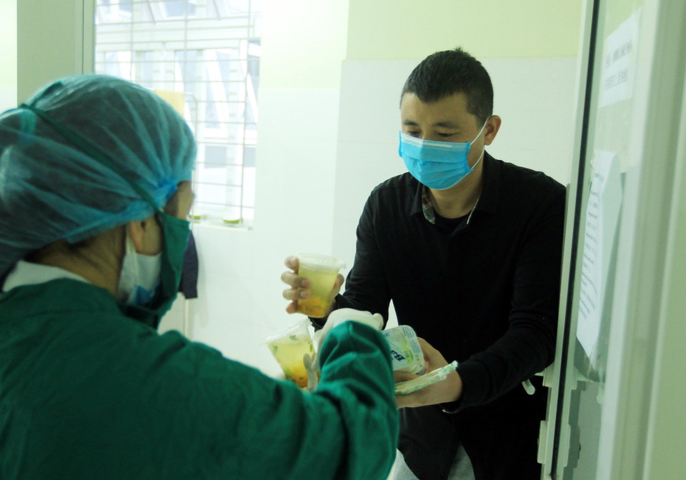 Công dân Trung Quốc nhận những suất ăn của các y bác sỹ mang đến từng phòng. (Ảnh: An Đăng/TTXVN)