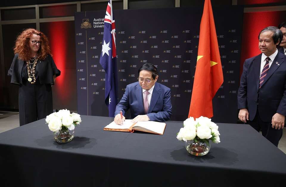 Thủ tướng Phạm Minh Chính ký sổ lưu niệm khi đến thăm Trường Đại học Quốc gia Australia (ANU). (Ảnh: Dương Giang/TTXVN)