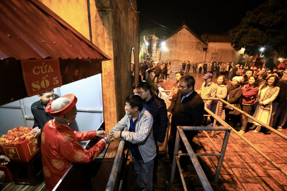 Người dân và du khách xếp hàng trật tự để nhận túi lương đền Trần đầu năm mới. (Ảnh: Nhật Anh/TTXVN)