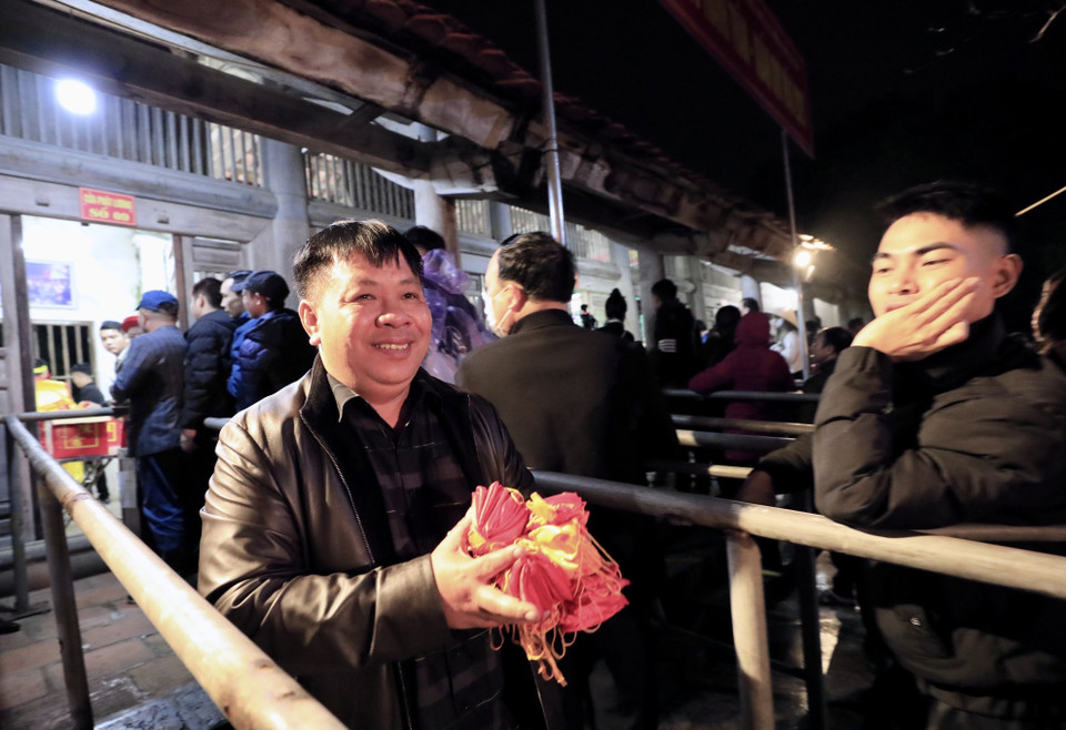 Người dân và du khách đến dự lễ vui mừng khi được nhận những túi lương với hy vọng năm mới gia đình no ấm, đủ đầy. (Ảnh: Nhật Anh/TTXVN)