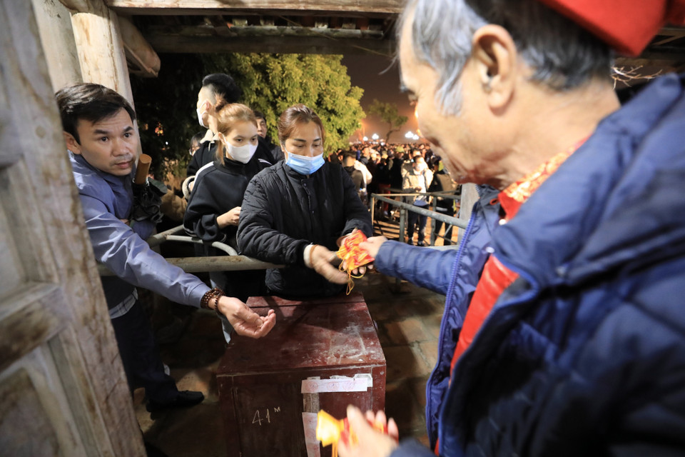 Các cụ bô lão trong làng phụ trách việc phát lương. (Ảnh: Nhật Anh/TTXVN)