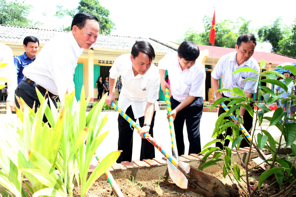 Ban lãnh đạo cơ quan và Hiệu trường trường tiểu học Hoàng Lâu trồng cây lưu niệm. (Doãn Đức/Vietnam+)