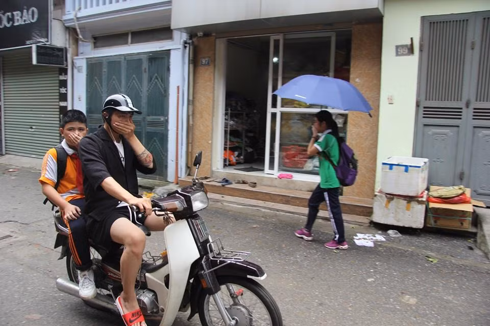 Người dân bịt mũi vì mùi khó chịu bốc ra từ khu vực bị cháy. (Ảnh: Sơn Bách/Vietnam+)