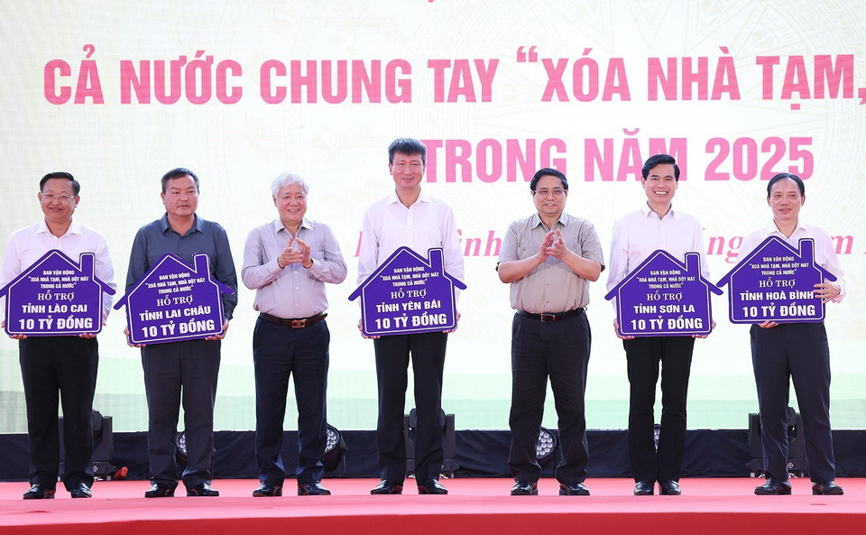 Thủ tướng Phạm Minh Chính và Chủ tịch Ủy ban Trung ương Mặt trận Tổ quốc Việt Nam Đỗ Văn Chiến trao biểu trưng phân bổ hỗ trợ kinh phí xoá nhà tạm, nhà dột nát cho các tỉnh. (Ảnh: Dương Giang/TTXVN)
