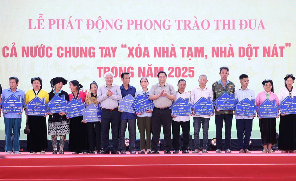 Thủ tướng Phạm Minh Chính và Chủ tịch Ủy ban Trung ương Mặt trận Tổ quốc Việt Nam Đỗ Văn Chiến trao biểu trưng hỗ trợ nhà đại đoàn kết cho các hộ gia đình tại huyện Đà Bắc, tỉnh Hòa Bình. (Ảnh: Dương Giang/TTXVN)