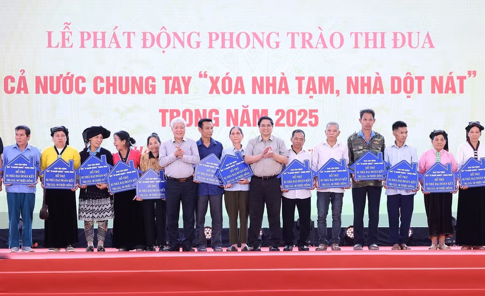 Thủ tướng Phạm Minh Chính và Chủ tịch Ủy ban Trung ương Mặt trận Tổ quốc Việt Nam Đỗ Văn Chiến trao biểu trưng hỗ trợ nhà đại đoàn kết cho các hộ gia đình tại huyện Đà Bắc, tỉnh Hòa Bình. (Ảnh: Dương Giang/TTXVN)