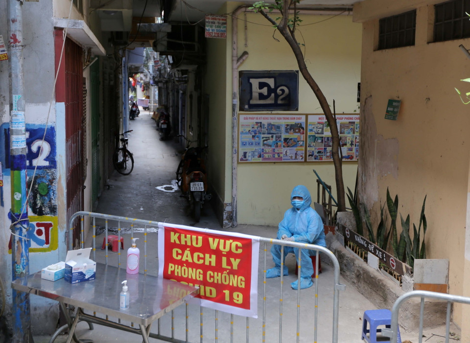 Sáng 10/5/2021, các lực lượng chức năng đã phong tỏa, cách ly y tế khu nhà E2, 128C Đại La, phường Đồng Tâm (quận Hai Bà Trưng, Hà Nội), nơi ở của cháu bé sinh năm 2020 có kết quả dương tính với SARS-CoV-2. Trong ảnh: Lực lượng chức năng chốt chặn 2 lối vào khu nhà E2. (Ảnh: Hoàng Hiếu/TTXVN)