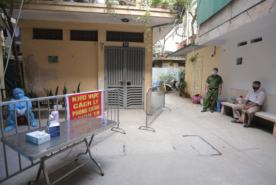 Lực lượng chức năng chốt chặn 2 lối vào khu nhà E2. (Ảnh: Hoàng Hiếu/TTXVN)