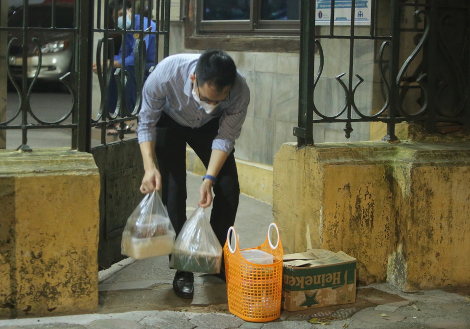 Cán bộ, nhân viên Bộ Giao thông Vận tải nhận đồ do người thân chuyển vào. (Ảnh: Hoàng Hiếu/TTXVN)