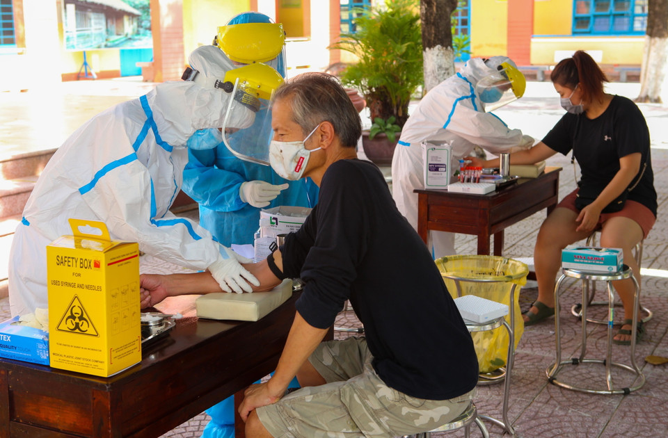 Nhân viên y tế lấy mẫu xét nghiệm cho người nước ngoài tại quận Sơn Trà (Đà Nẵng). (Ảnh: Trần Lê Lâm/TTXVN)