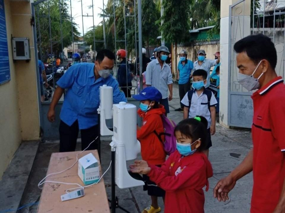 Sáng 14/2, học sinh bậc tiểu học và mầm non, mẫu giáo trên địa bàn tỉnh Bến Tre trở lại trường học trực tiếp sau thời gian học trực tuyến do bị ảnh hưởng của dịch COVID-19. Trong ảnh: Các học sinh được hướng dẫn rửa tay, kiểm tra thân nhiệt trước khi vào trường. (Ảnh: TTXVN phát)