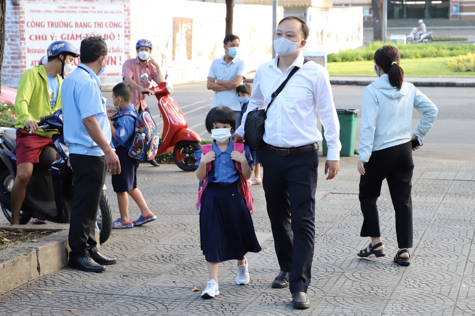 Phụ huynh trường tiểu học Hòa Bình (Quận 1) đưa con đến trường. (Ảnh: Hồng Giang/TTXVN)