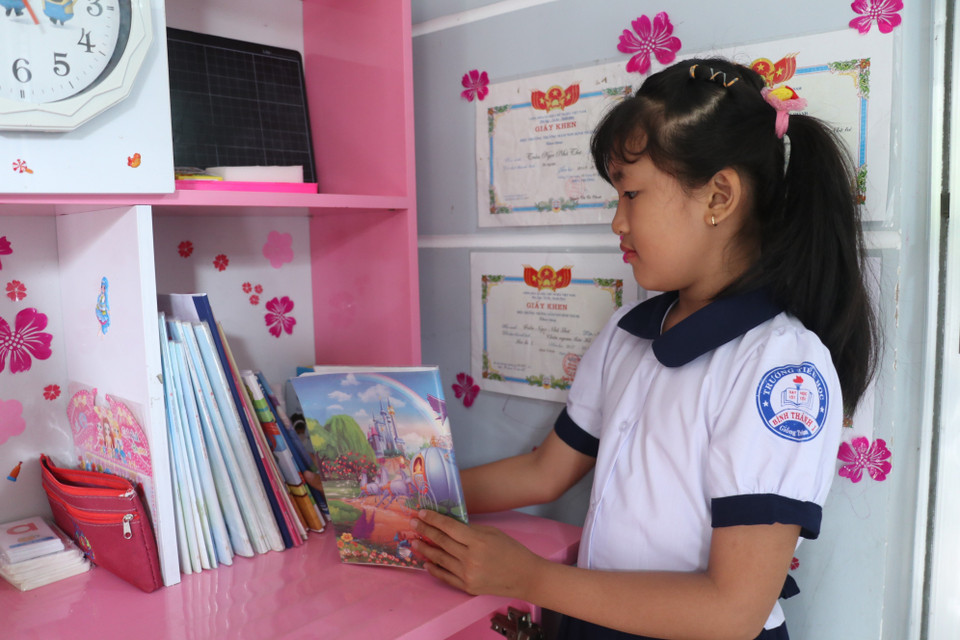 Em Trần Ngọc Nhã Thanh học sinh trường Tiểu học Bình Thạnh 1, huyện Giồng Trôm, tỉnh Bến Tre háo hức chuẩn bị tập, sách khi ngày đầu tiên được đến trường. (Ảnh: Chương Đài/TTXVN)