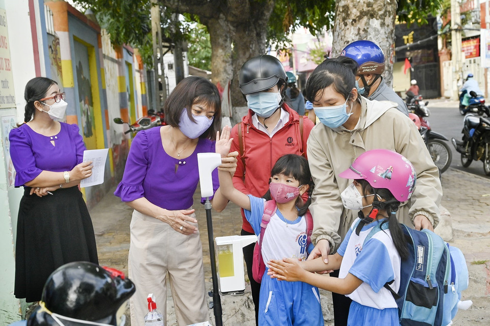 Các cô giáo hướng dẫn trẻ sát khuẩn tay trước khi vào lớp. (Ảnh: Hồng Hiếu/TTXVN)