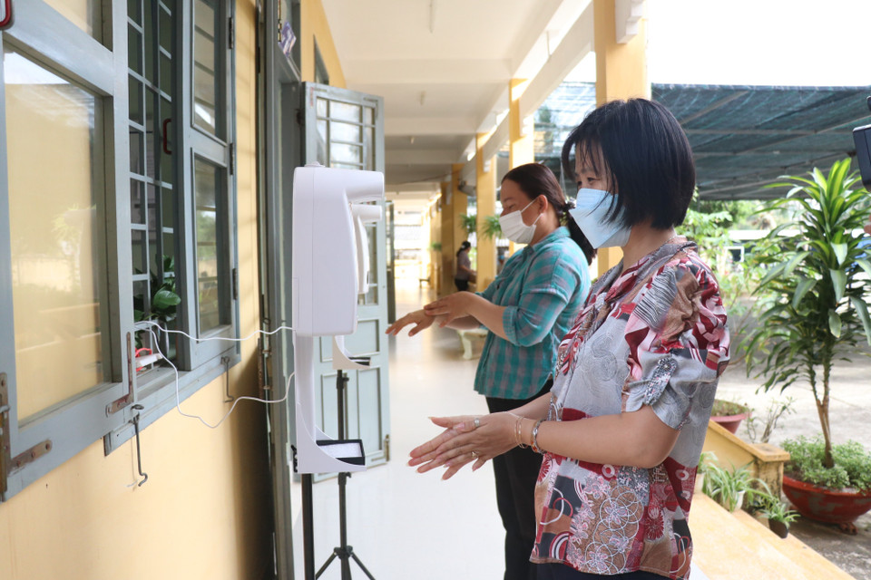Các giáo viên trường Tiểu học Bình Thạnh 1, huyện Giồng Trôm, tỉnh Bến Tre đảm bảo an toàn vệ sinh khi đón học sinh đến trường. (Ảnh: Chương Đài/TTXVN)