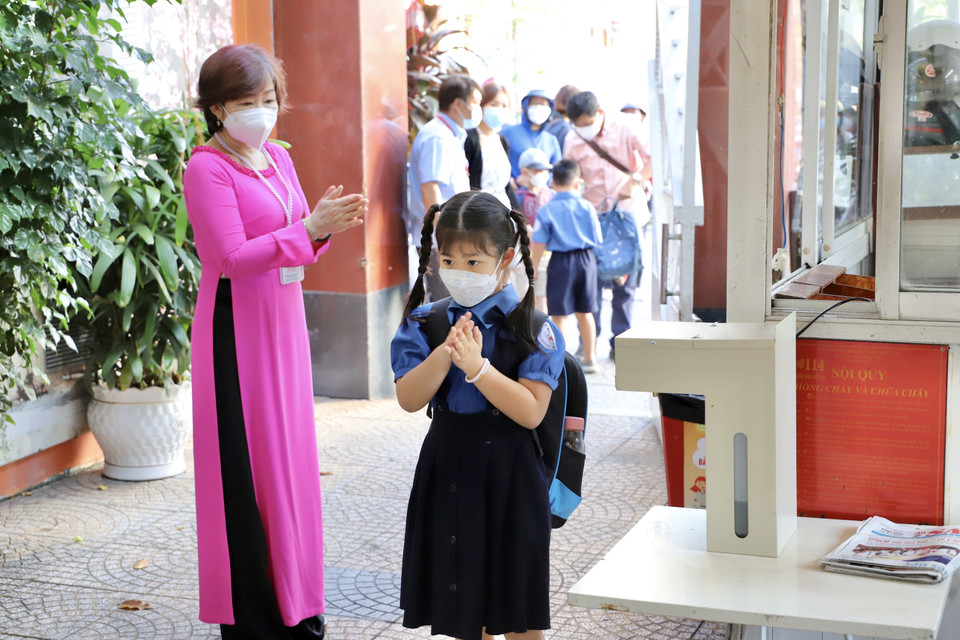 Cô Tống Thị Mai Hương, Phó Hiệu trưởng trường tiểu học Hoà Bình (Quận 1), hướng dẫn học sinh rửa tay trước khi vào lớp. (Ảnh: Hồng Giang/TTXVN)