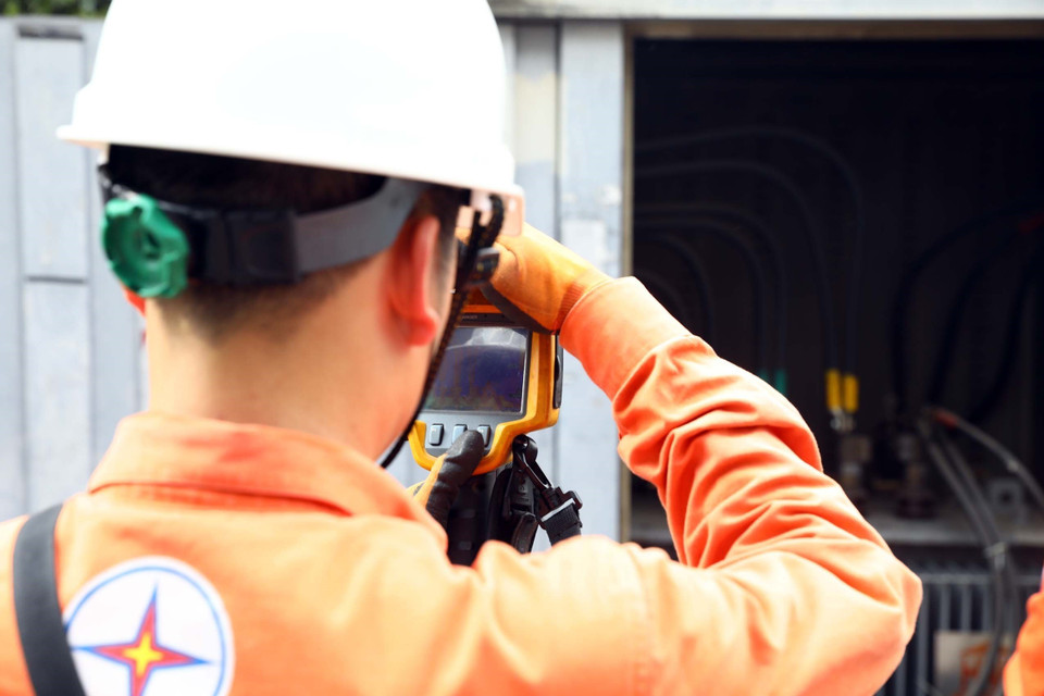 Công nhân Công ty Điện lực Hai Bà Trưng kiểm tra hệ thống phụ tải điện tại các điểm xung yếu. (Ảnh: Huy Hùng/TTXVN)