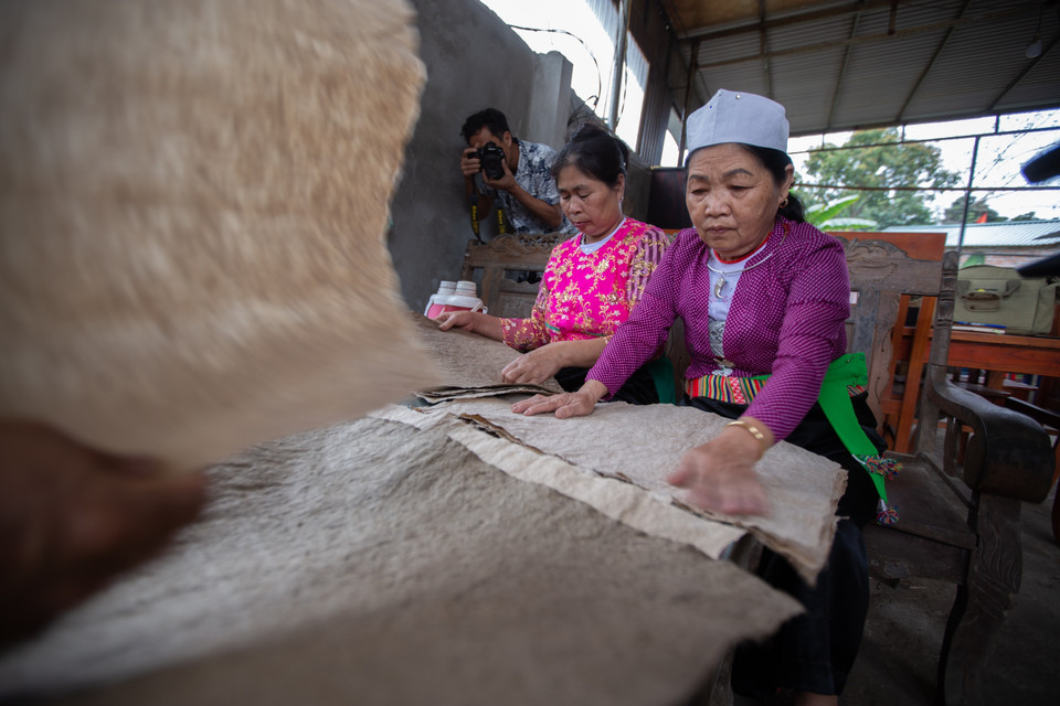 Công đoạn cuối cùng cho ra giấy dó thành phẩm là vuốt phẳng giấy xếp thành từng tập để giao cho người mua. (Ảnh: Trọng Đạt/TTXVN)