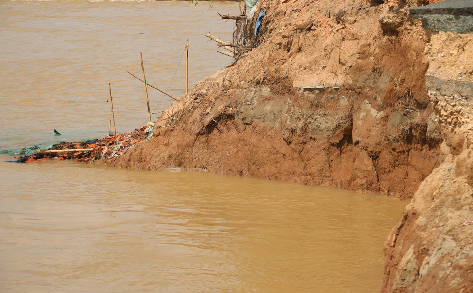 Vết cát mới màu xanh là vị trí các bao cát mà đơn vị thi công đã thả xuống sông Hậu trước đó nhằm ổn định đường bờ, gia cố mái taluy để khắc phục sự cố sạt lở Quốc lộ 91 đoạn qua ấp Bình Tân, xã Bình Mỹ cao hơn mặt nước sông Hậu khoảng 1m đã bị sạt hoàn toàn xuống sông Hậu. (Ảnh: Công Mạo/TTXVN)
