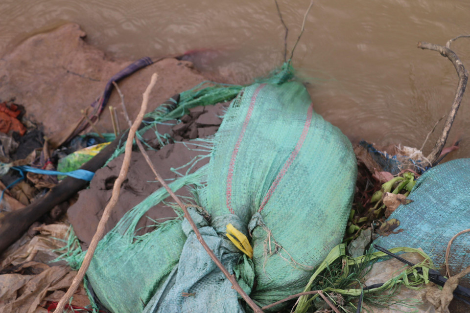 Các bao cát do đơn vị thi công đã thả xuống sông Hậu trước đó nhằm ổn định đường bờ, gia cố mái taluy để khắc phục sự cố sạt lở Quốc lộ 91 còn sót lại ở mé bờ sạt lở. (Ảnh: Công Mạo/TTXVN)