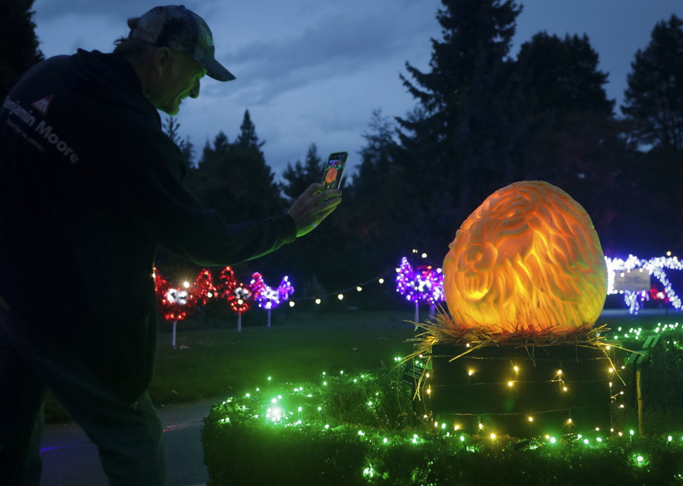 Người dân chiêm ngưỡng các tác phẩm điêu khắc từ bí ngô tại sự kiện "Ánh sáng trong khu vườn" với chủ đề Halloween ở Vancouver, Canada, ngày 16/10/2019. (Ảnh: THX/TTXVN)