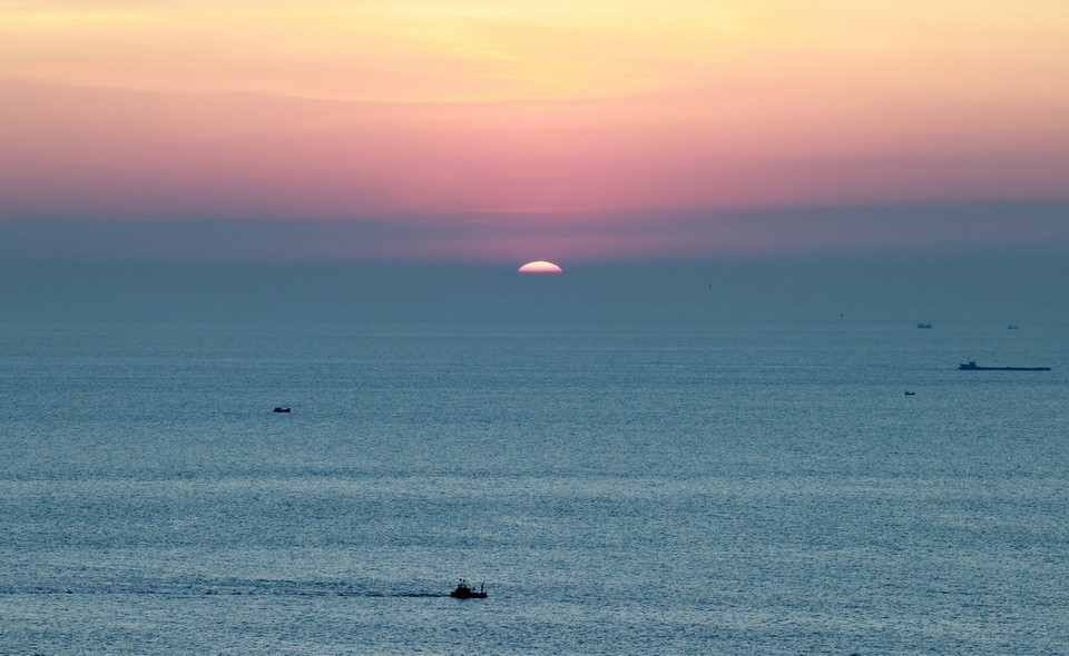 Khoảnh khắc đón bình minh đầu tiên giữa khung cảnh biển trời hòa làm một. (Ảnh: Nhật Anh/TTXVN)