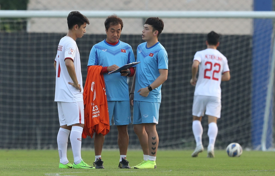 Trợ lý Lee Young Jin (giữa) nói chuyện riêng với tiền vệ Nguyễn Trọng Hùng (trái) trong buổi tập. (Ảnh: Hoàng Linh/TTXVN)