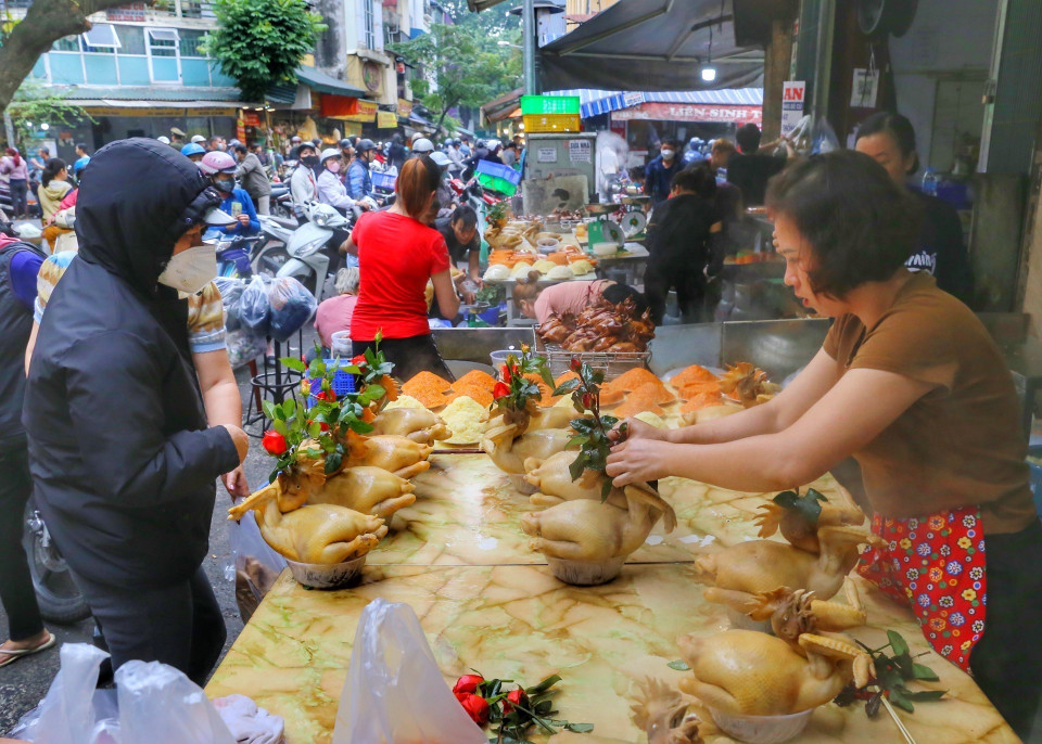 Người dân Thủ đô mua sắm đồ cúng ông Công, ông Táo. (Ảnh: Tuấn Đức/TTXVN)