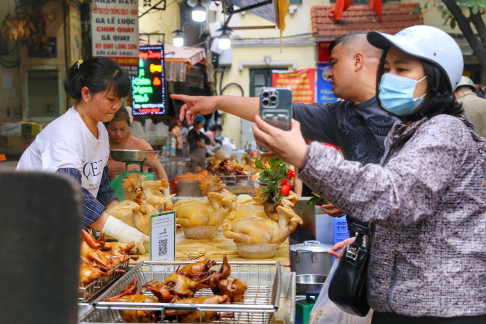 Người dân Thủ đô mua sắm đồ cúng ông Công, ông Táo. (Ảnh: Tuấn Đức/TTXVN)