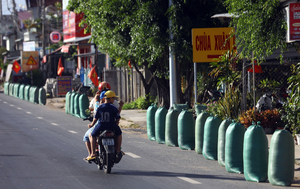 Những bao thóc vừa thu hoạch được đóng gói xếp hàng chờ được chở về kho. (Ảnh: Huy Hùng/TTXVN)