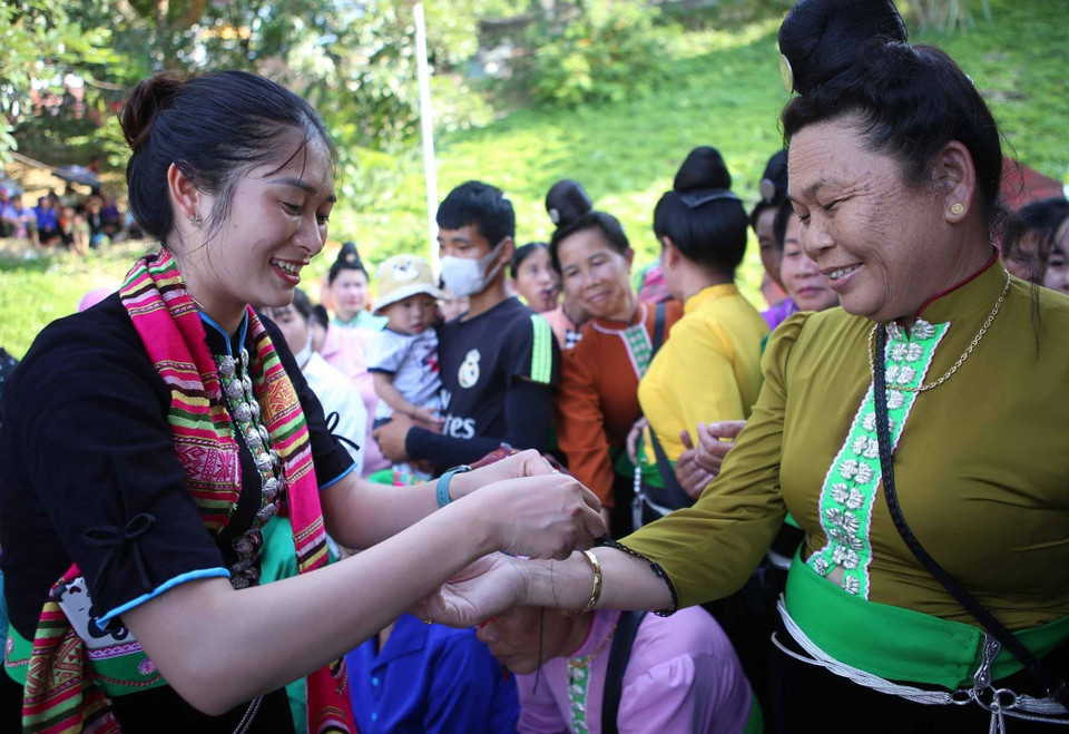 Buộc chỉ tay theo quan niệm của người Thái để mong sức khỏe, bình an, gia đình hạnh phúc. (Ảnh: Quý Trung/TTXVN)