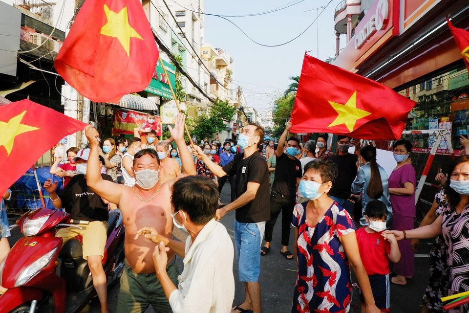 Người dân hẻm 245 Nguyễn Trãi (phường Nguyễn Cư Trinh, Quận 1, Thành phố Hồ Chí Minh) vui mừng khi được gỡ bỏ phong tỏa vào chiều mùng 4 Tết. (Ảnh: TTXVN phát)