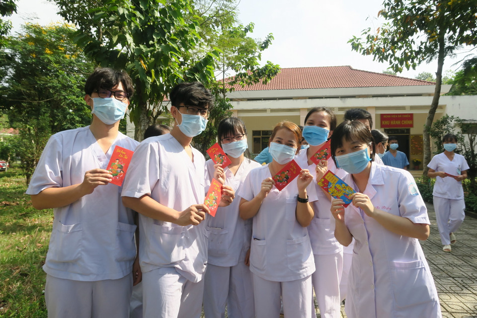 Nhân viên y tế trực Tết tại Bệnh viện Dã chiến Củ Chi nhận ''lì xì'' của lãnh đạo Sở Y tế Thành phố Hồ Chí Minh. (Ảnh: Đinh Hằng/TTXVN)