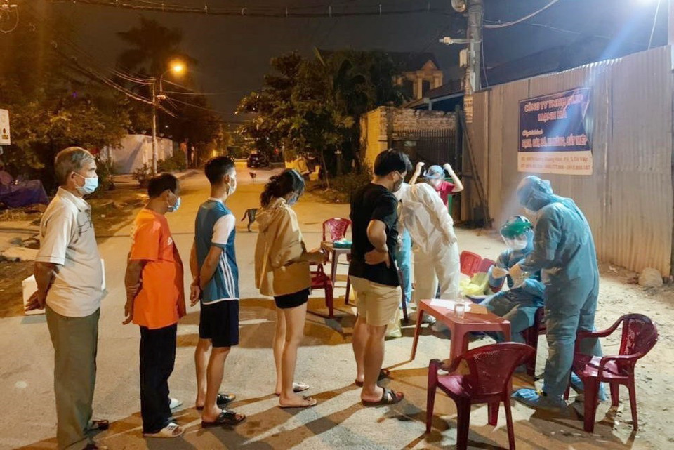 Nhân viên y tế lấy mẫu xét nghiệm cho người dân quận Gò Vấp, Thành phố Hồ Chí Minh tối 30 Tết. (Ảnh: TTXVN phát)