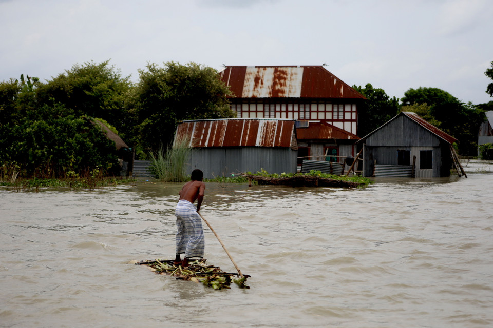 Người dân đi bè qua khu vực ngập lụt sau mưa lớn tại Munshiganj, ngoại đô Dhaka, Bangladesh, ngày 27/7/2020. (Ảnh: THX/TTXVN)