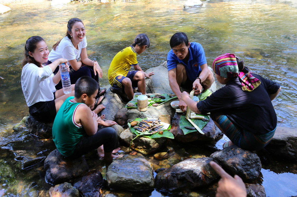 Cách thành phố Đông Hà gần 70km, xã Tà Long (huyện Đakrông, tỉnh Quảng Trị) có hệ thống ghềnh thác, khe suối chảy quanh co giữa những khu rừng già, cùng thảm thực vật phong phú, đa dạng và quý hiếm đã tạo điều kiện cho các hoạt động du lịch sinh thái, du lịch khám phá…. Trong ảnh: Du khách thưởng thức đặc sản của địa phương bên dòng suối Tà Lao mát lạnh. (Ảnh: Hồ Cầu/TTXVN)