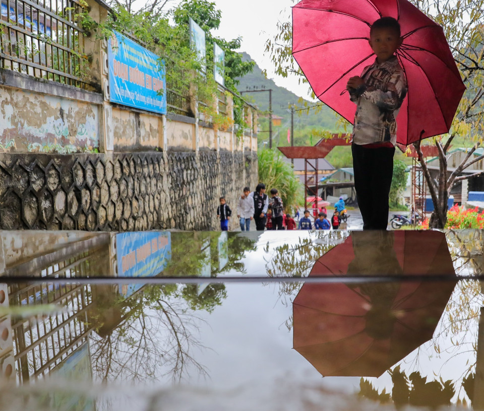 Mưa lớn kéo dài khiến việc tới trường của học sinh Trường Phổ thông dân tộc bán trú Tiểu học Cán Chu Phìn (Mèo Vạc) khó khăn, vất vả hơn. (Ảnh: Nam Thái/TTXVN)