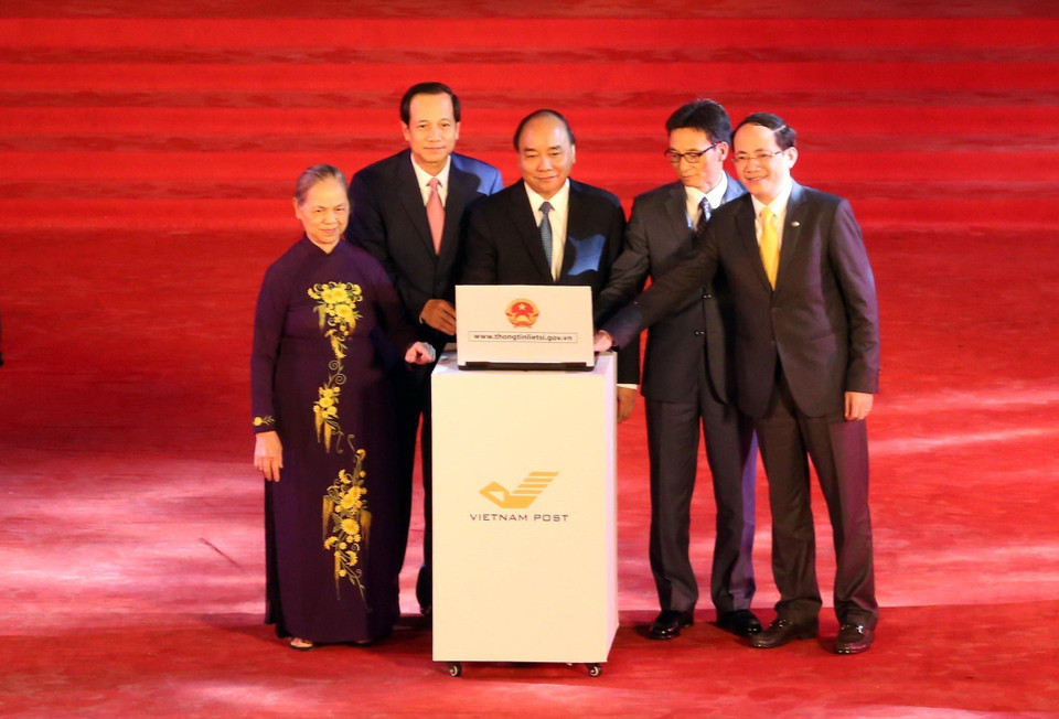 Thủ tướng Nguyễn Xuân Phúc, Phó Thủ tướng Vũ Đức Đam và các đại biểu nhấn nút khai trương Cổng thông tin điện tử dữ liệu về liệt sỹ, mộ phần liệt sỹ, nghĩa trang liệt sỹ toàn quốc tại địa chỉ thongtinlietsi.gov.vn, tối 26/7/2018, tại Nghĩa trang liệt sỹ thị xã Sơn Tây, Hà Nội. (Ảnh: Anh Tuấn/TTXVN)