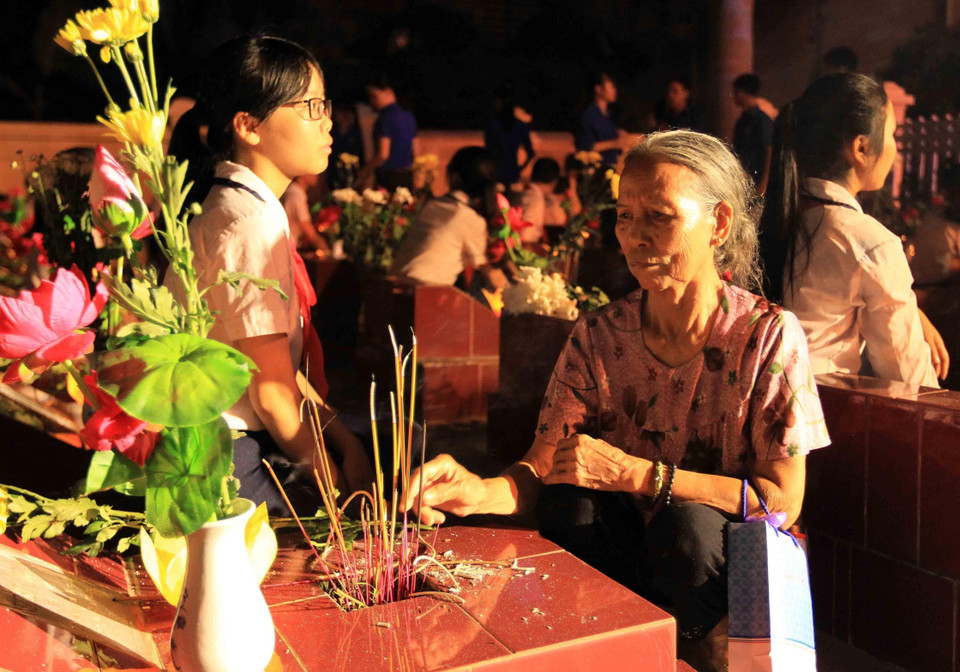 Người mẹ già thắp hương trên phần mộ con trai đã hy sinh trong cuộc chiến tranh giải phóng đất nước, tại Lễ thắp nến tri ân các Anh hùng, liệt sỹ ở Nghĩa trang liệt sỹ phường Nam Sơn, quận Kiến An, thành phố Hải Phòng, tối 26/7/2018. (Ảnh: An Đăng/TTXVN)