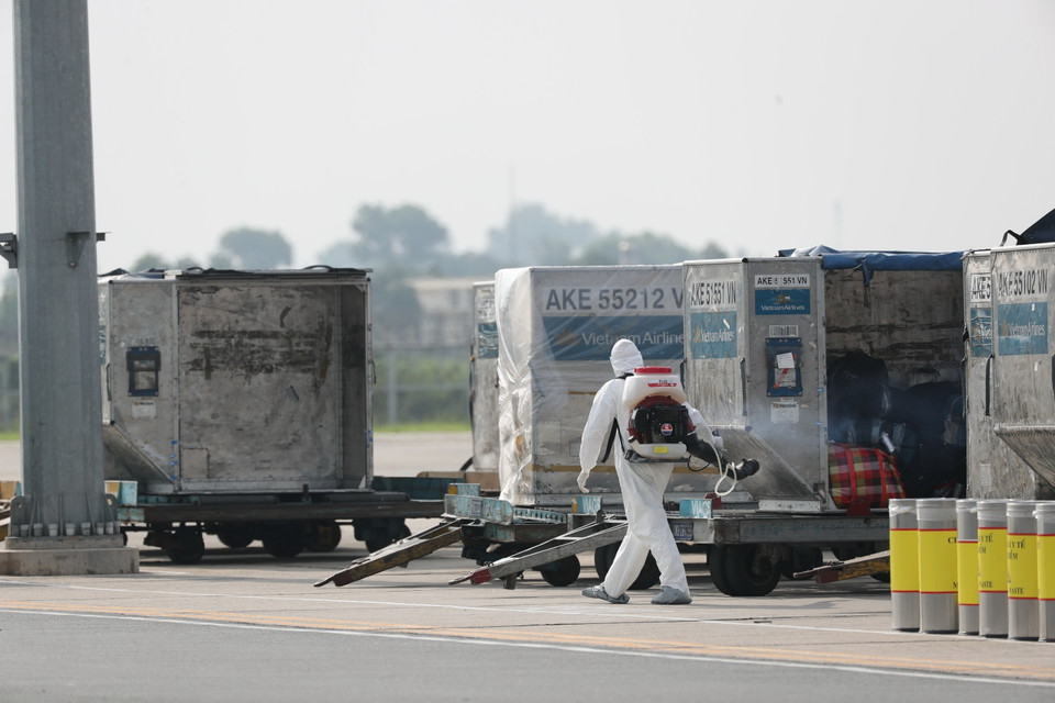 Toàn bộ hành lý của chuyến bay được phun khử trùng ngay khi chuyển ra khỏi máy bay. (Ảnh: Thành Đạt/TTXVN)