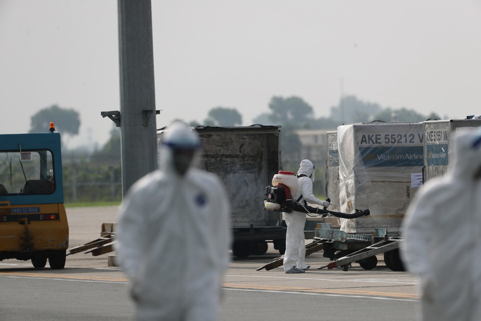 Toàn bộ hành lý của chuyến bay được phun khử trùng ngay khi chuyển ra khỏi máy bay. (Ảnh: Thành Đạt/TTXVN)