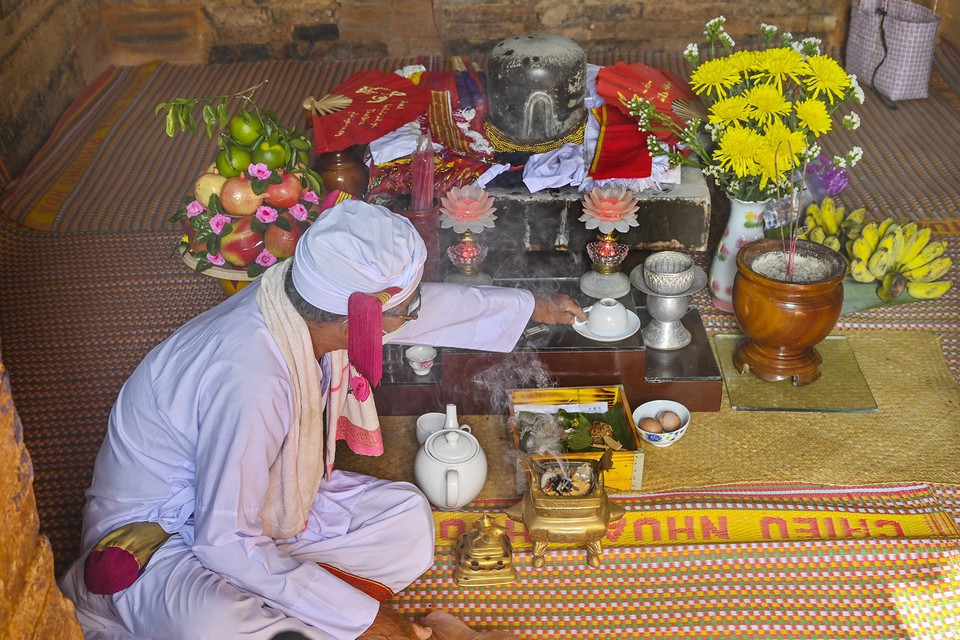 Thực hiện nghi lễ cúng tháp Pô Sah Inư. (Ảnh: Nguyễn Thanh/TTXVN)