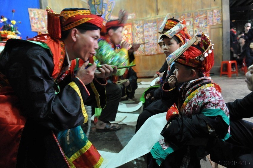 Thầy cúng làm lễ cấp binh khí cho trò tại Lễ hội “Cấp sắc” - nghi lễ không thể thiếu của người Dao đỏ. (Ảnh: TTXVN)