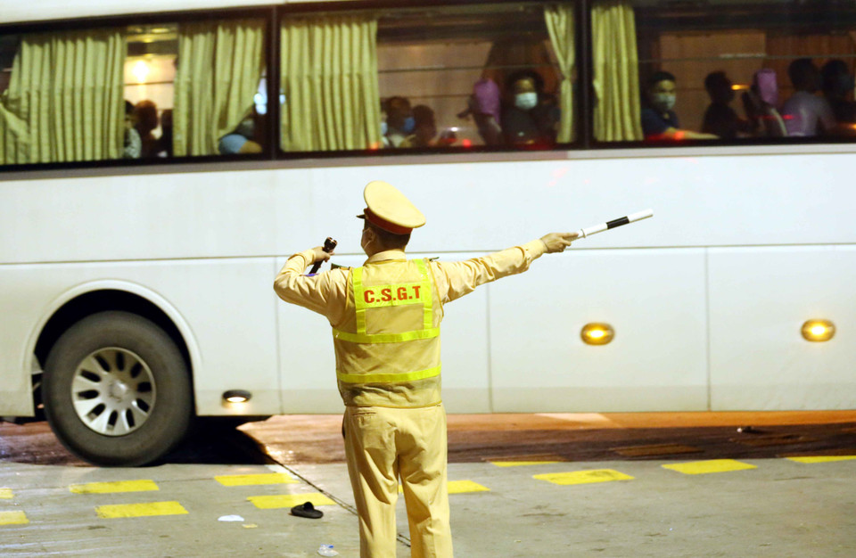 Lực lượng cảnh sát giao thông tại trạm thu phí Pháp Vân-Cầu Giẽ điều tiết giao thông, yêu cầu các phương tiện phải quay đầu nếu không đủ điều kiện vào Thủ đô. (Ảnh: Phạm Kiên/TTXVN)