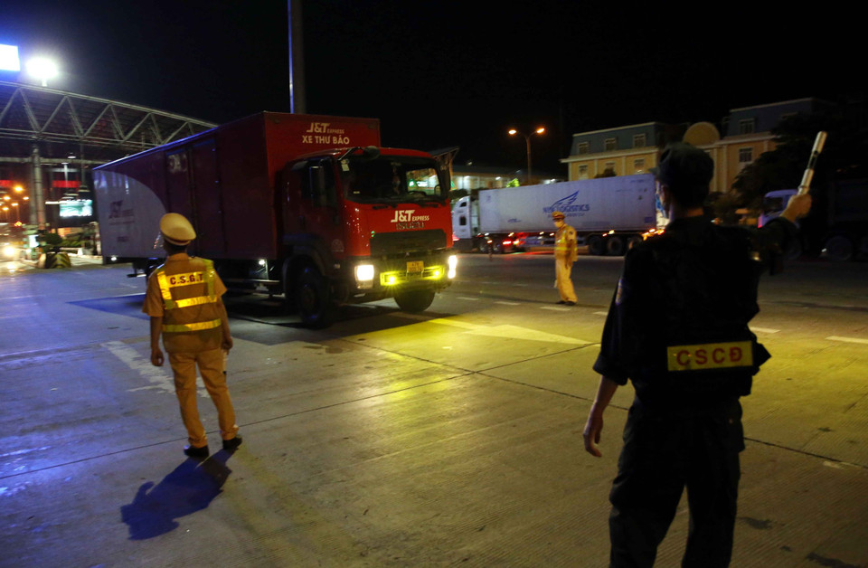 Lực lượng cảnh sát kiểm soát các phương tiện giao thông tại trạm thu phí Pháp Vân-Cầu Giẽ. (Ảnh: Phạm Kiên/TTXVN)