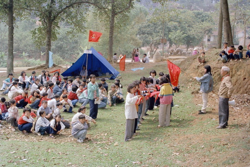 Trao khăn quàng đỏ cho đội viên mới tại buổi giao lưu của các trường trên địa bàn thủ đô trên núi Tiên Lữ, huyện Chương Mỹ, Hà Tây (1997). (Ảnh: Tuấn Hải/TTXVN)