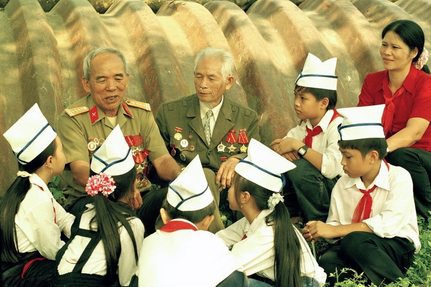 Đội viên trường THCS Mường Thanh (Điện Biên) nghe cựu đại tá Nông Văn Khâu, nguyên Phó Tư lệnh Quân khu II, Trưởng Ban Liên lạc chiến sỹ Điện Biên, Chủ tịch Hội Cựu chiến binh tỉnh Lai Châu kể chuyện về chiến dịch Điện Biên (2003). (Ảnh: Thanh Hà/TTXVN)