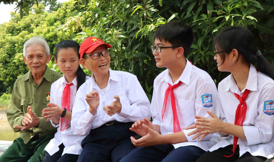 Các cựu đội viên Đội Thiếu niên du kích Đình Bảng giao lưu với học sinh tại Lăng Lòng chảo, phường Đình Bảng, thị xã Từ Sơn, tỉnh Bắc Ninh (30/8/2019). (Ảnh: Diệp Trương/TTXVN)