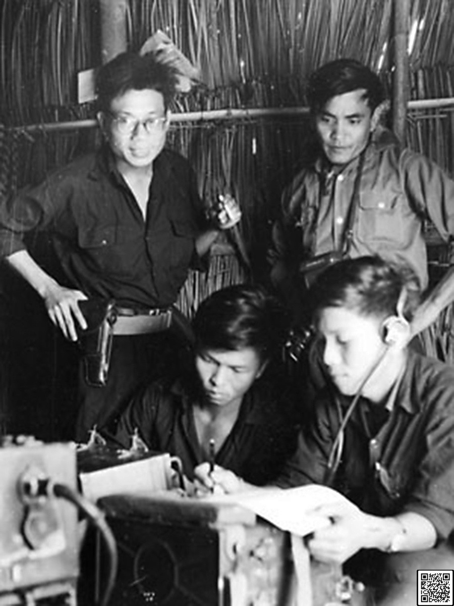 Nhà báo Lâm Tấn Tài (người đứng bìa phải) đang theo dõi truyền tin bài về cứ tại một tổ phóng viên Thông tấn xã Giải phóng tác nghiệp tại vùng ven Sài Gòn trươc cuộc Tổng tiến công và nổi dậy Xuân Mậu Thân 1968. (Ảnh: Thông tấn xã Giải phóng)