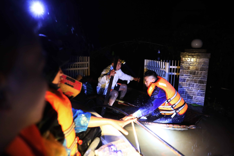 Lực lượng quân đội tỉnh Hà Tĩnh bơi thuyền vào cứu trợ ông Phan Thanh Đức bị cô lập tại thôn Ngũ Phúc, xã Cẩm Vĩnh, huyện Cẩm Xuyên. (Ảnh chụp đêm 20/10/2020). (Ảnh: TTXVN)